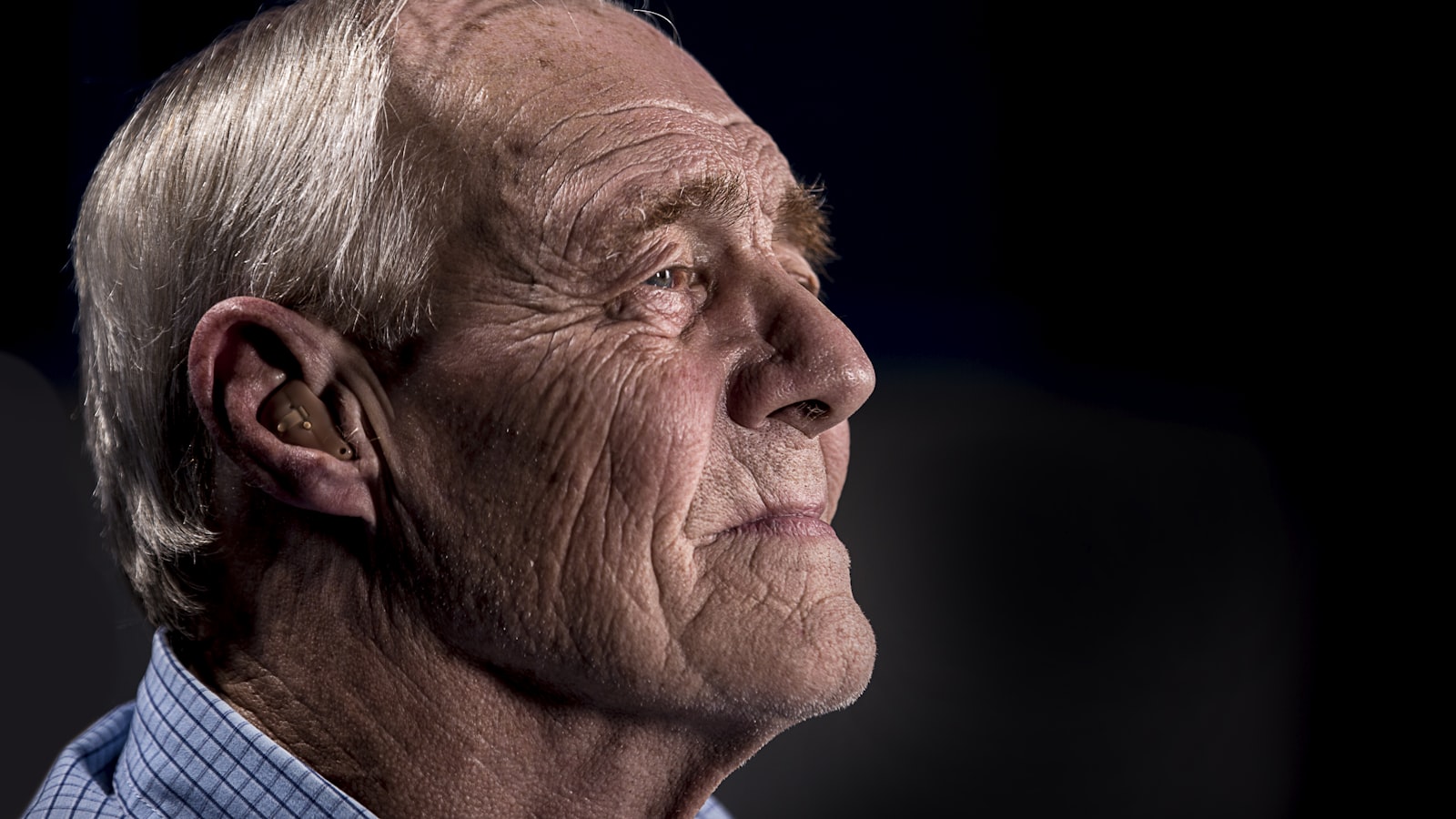 Personne retraitée pensive à sa fenêtre